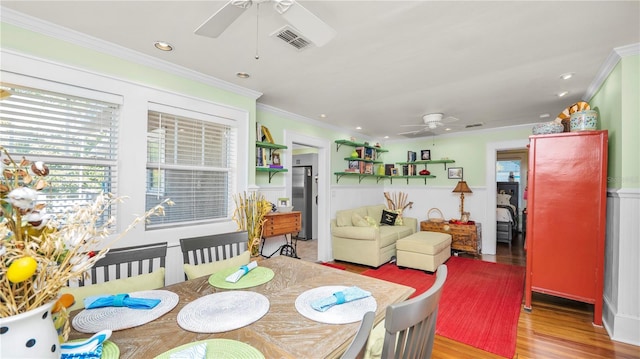 dining room with ornamental molding, ceiling fan, and light hardwood / wood-style floors