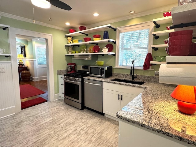 kitchen with sink, crown molding, appliances with stainless steel finishes, stone counters, and white cabinets