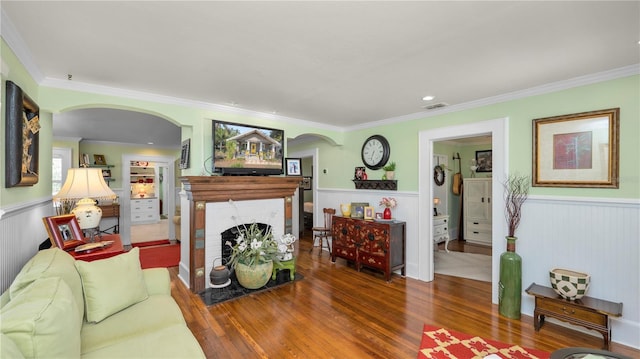 living room featuring crown molding, dark hardwood / wood-style floors, and a brick fireplace