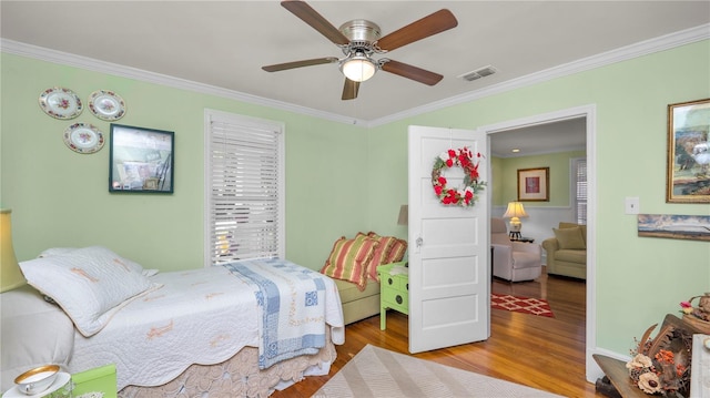 bedroom featuring ceiling fan, ornamental molding, and light hardwood / wood-style flooring