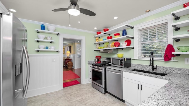 kitchen featuring appliances with stainless steel finishes, light stone countertops, sink, and white cabinets