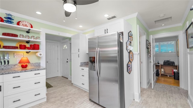 kitchen featuring white cabinetry, light stone counters, ornamental molding, stainless steel fridge with ice dispenser, and light wood-type flooring