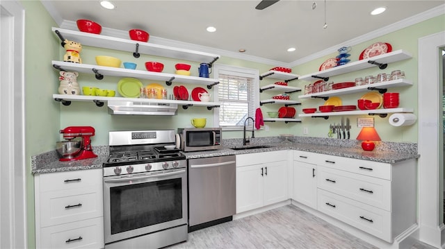 kitchen with sink, white cabinetry, crown molding, stainless steel appliances, and light stone countertops