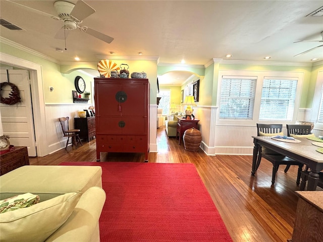 living room with hardwood / wood-style floors, crown molding, and ceiling fan