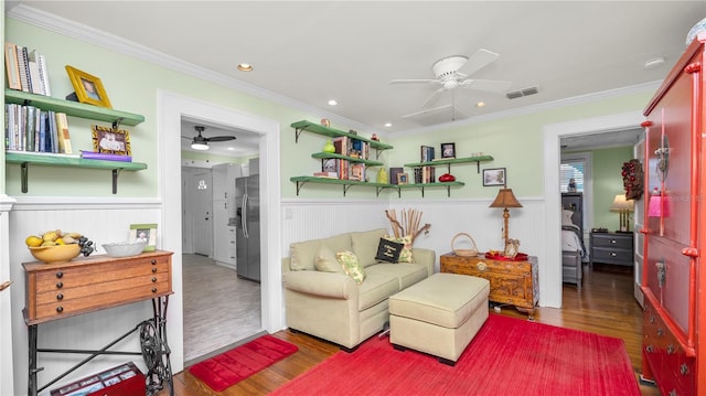 sitting room with ceiling fan, ornamental molding, and dark hardwood / wood-style floors