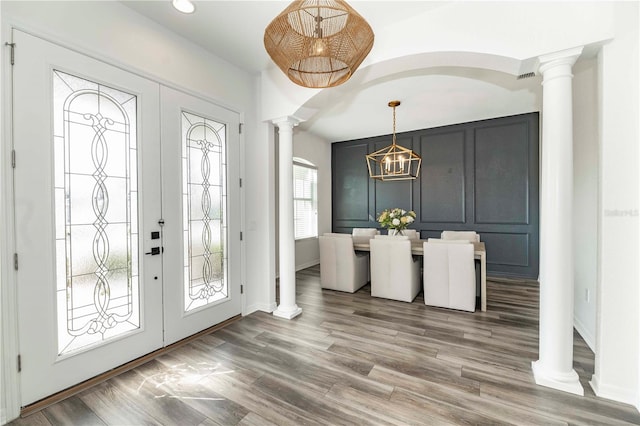 foyer entrance with french doors, wood-type flooring, and ornate columns