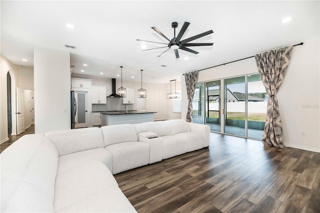 living room with dark hardwood / wood-style flooring and ceiling fan