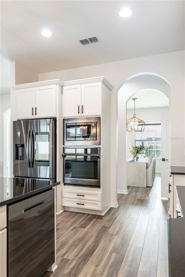 kitchen featuring appliances with stainless steel finishes, wood-type flooring, and white cabinets