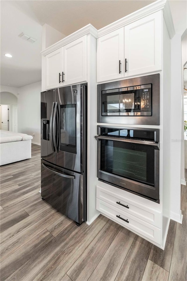 kitchen featuring white cabinetry, stainless steel appliances, and light hardwood / wood-style floors