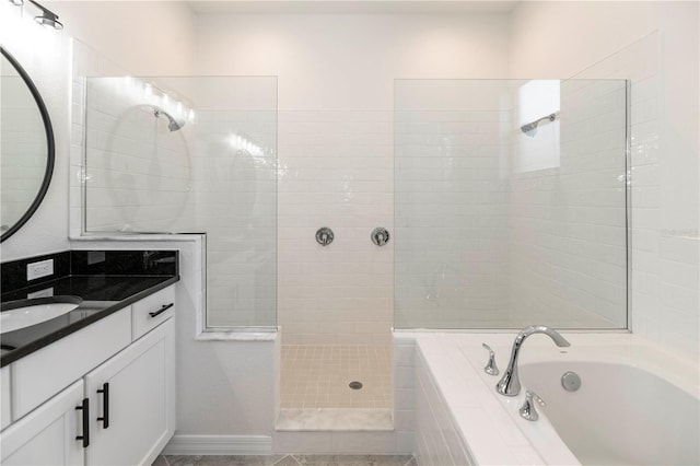 bathroom featuring vanity and independent shower and bath