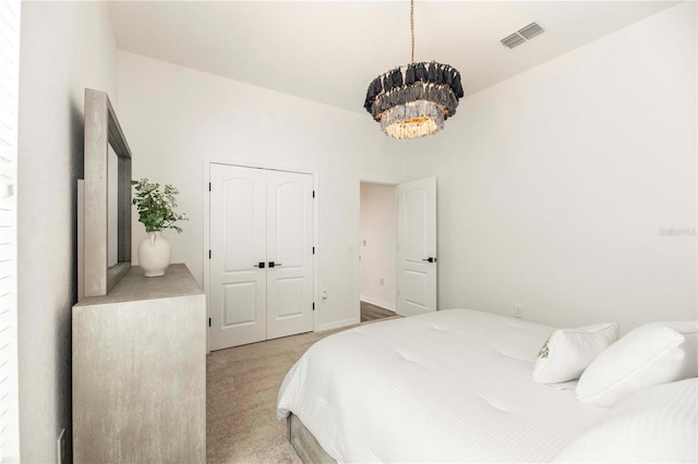 carpeted bedroom with a notable chandelier and a closet