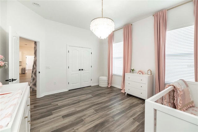 bedroom featuring dark hardwood / wood-style floors, a notable chandelier, and a closet