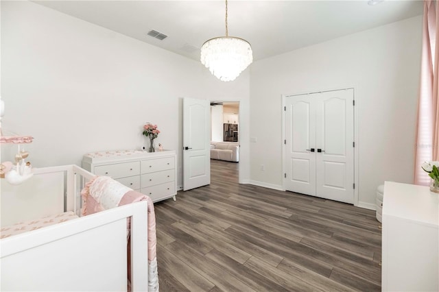 bedroom featuring dark hardwood / wood-style flooring and a chandelier