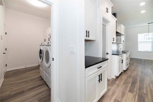 washroom with cabinets, dark hardwood / wood-style floors, and washing machine and dryer