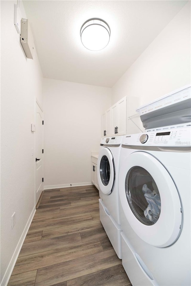 washroom featuring cabinets, separate washer and dryer, and dark hardwood / wood-style floors