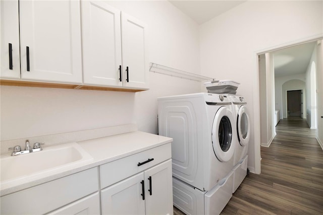 laundry room with cabinets, dark hardwood / wood-style floors, sink, and washing machine and clothes dryer