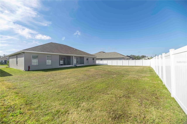 rear view of property featuring a lawn