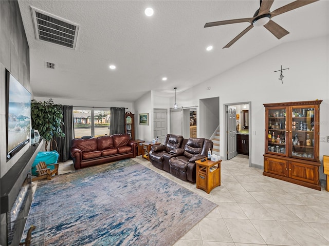 tiled living room with vaulted ceiling, ceiling fan, and a textured ceiling