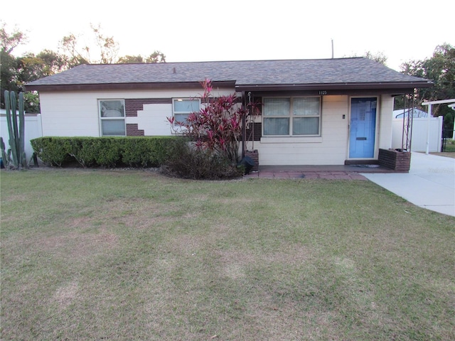 view of front of property featuring a front lawn and roof with shingles