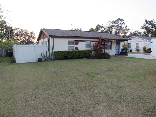 single story home with a front lawn and fence