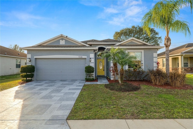 ranch-style home featuring a garage and a front lawn