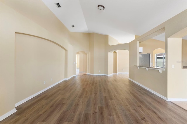 empty room featuring vaulted ceiling and dark wood-type flooring