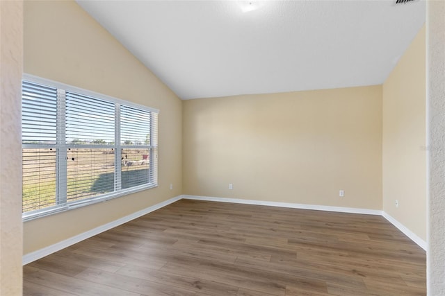 unfurnished room with lofted ceiling and hardwood / wood-style flooring