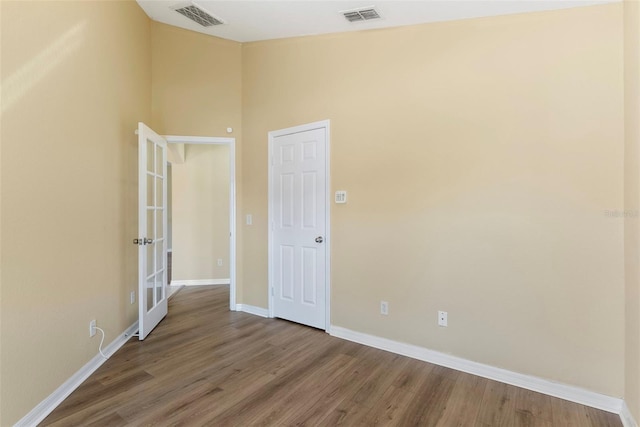 interior space featuring wood-type flooring, vaulted ceiling, and french doors