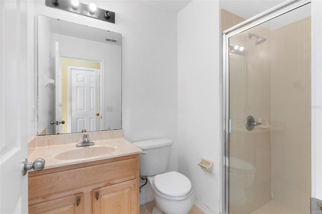 bathroom featuring a shower with door, vanity, and toilet