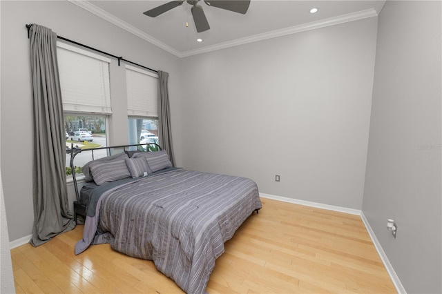 bedroom featuring ceiling fan, ornamental molding, and light hardwood / wood-style flooring