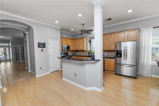 kitchen featuring stainless steel appliances, light hardwood / wood-style floors, ceiling fan, and ornate columns