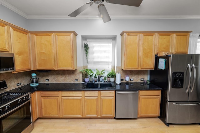 kitchen featuring dark stone countertops, sink, crown molding, and stainless steel appliances