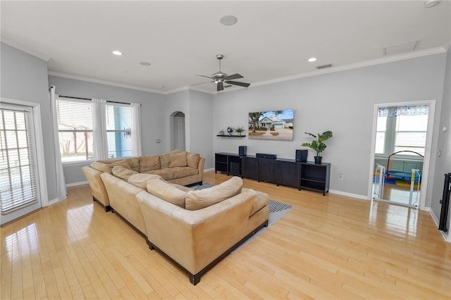 living room with light hardwood / wood-style flooring, ornamental molding, and ceiling fan