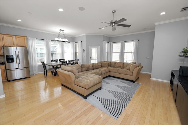 living room featuring ornamental molding, ceiling fan with notable chandelier, and light wood-type flooring