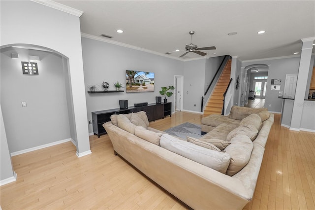 living room with crown molding, ceiling fan, and light hardwood / wood-style floors