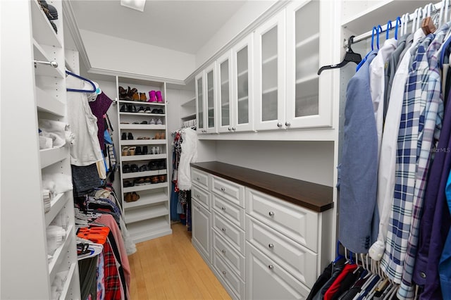 walk in closet with light hardwood / wood-style floors