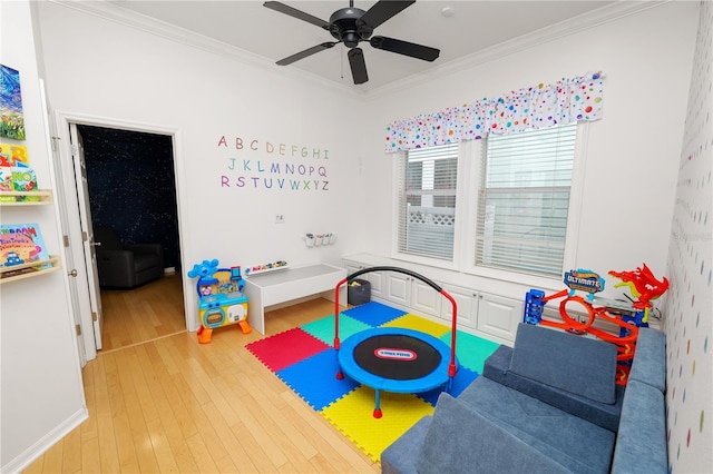 recreation room featuring crown molding, ceiling fan, and hardwood / wood-style flooring