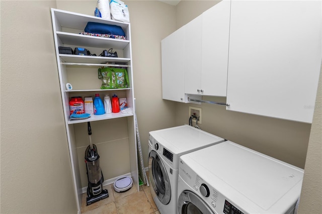 washroom featuring cabinets, light tile patterned flooring, and washing machine and clothes dryer