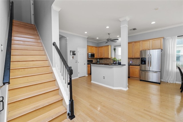 kitchen featuring tasteful backsplash, a wealth of natural light, light wood-type flooring, and appliances with stainless steel finishes