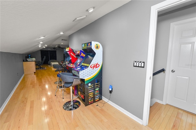 recreation room with wood-type flooring and vaulted ceiling