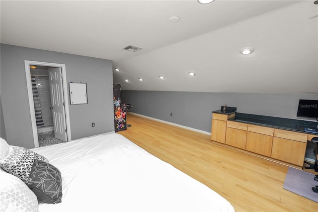 bedroom with lofted ceiling, built in desk, and light hardwood / wood-style floors