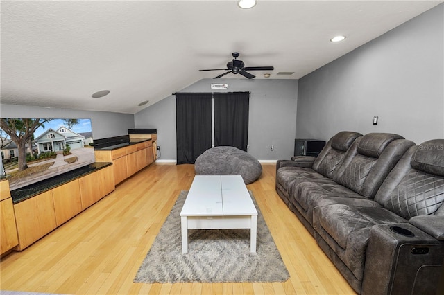 living room with vaulted ceiling, ceiling fan, and light wood-type flooring