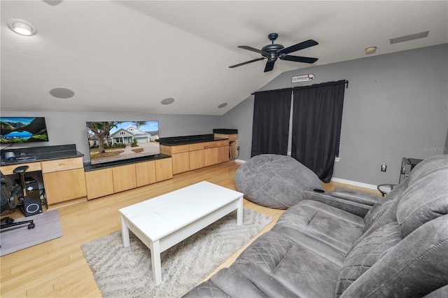 living room featuring ceiling fan, vaulted ceiling, and light hardwood / wood-style flooring