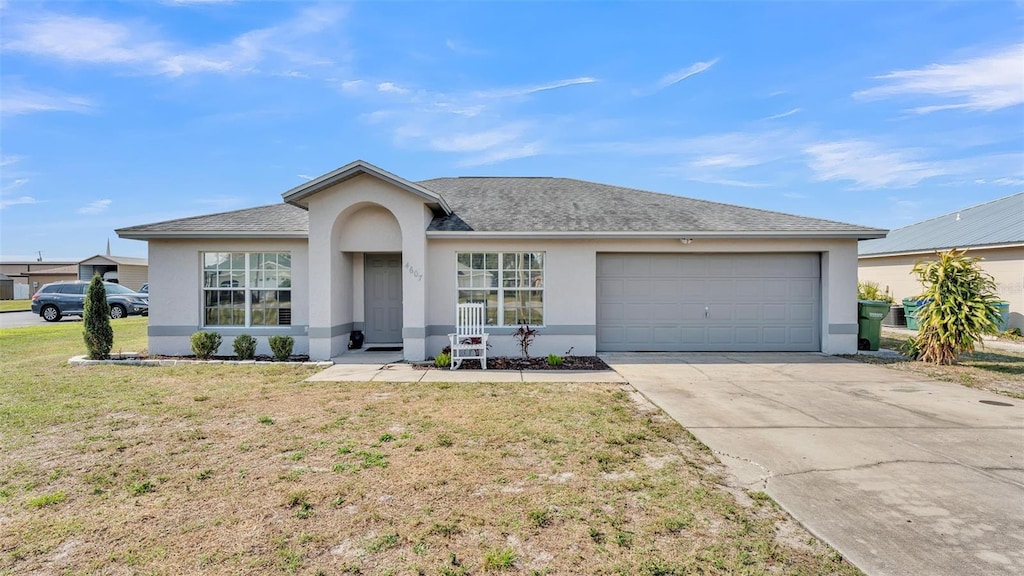 ranch-style house with a garage and a front lawn