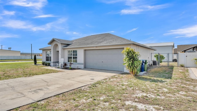 ranch-style home featuring cooling unit, a garage, and a front lawn