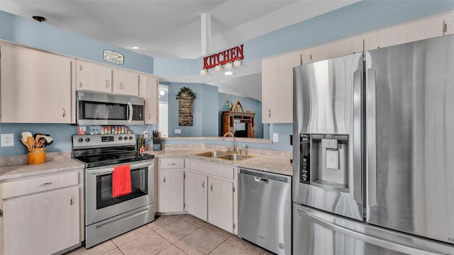 kitchen featuring light tile patterned flooring, stainless steel appliances, and sink