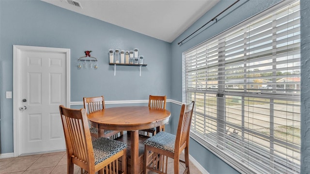 dining space featuring light tile patterned flooring and vaulted ceiling