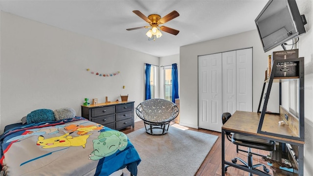 bedroom with ceiling fan, wood-type flooring, and a closet