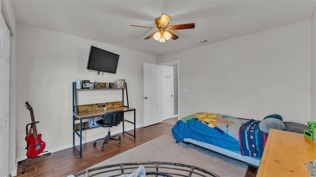 bedroom with dark hardwood / wood-style flooring and ceiling fan