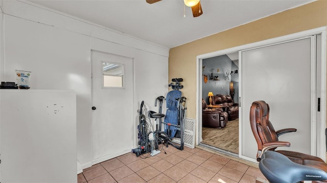 tiled home office featuring ceiling fan